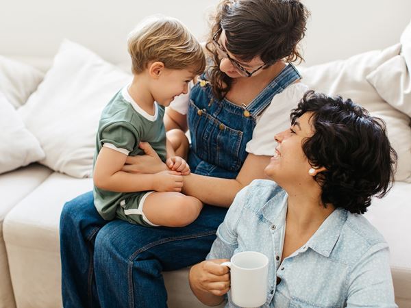 Smiling couple sitting on a sofa with their young son